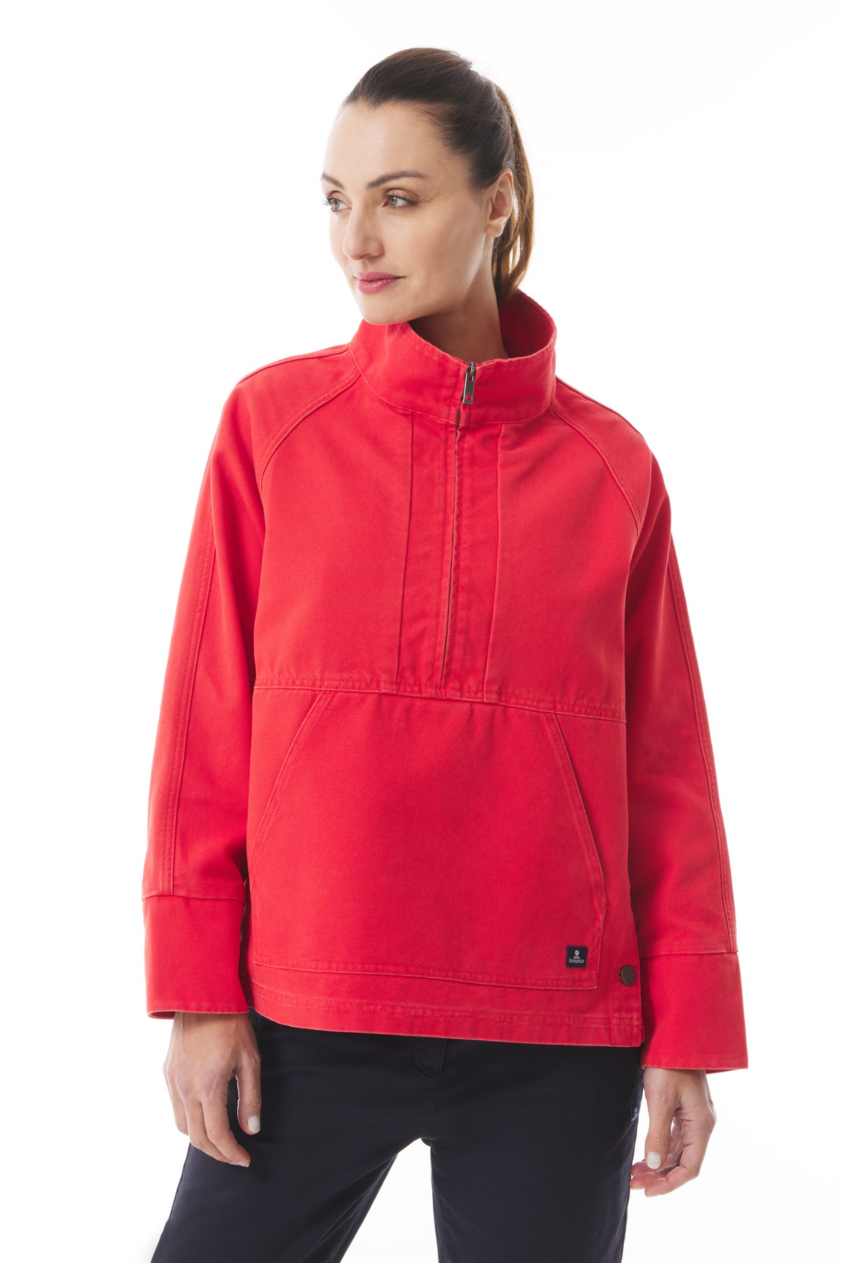 Image of a woman wearing the Mousqueton Yelli smock style top in Piment colour canvas, a bright orange red.