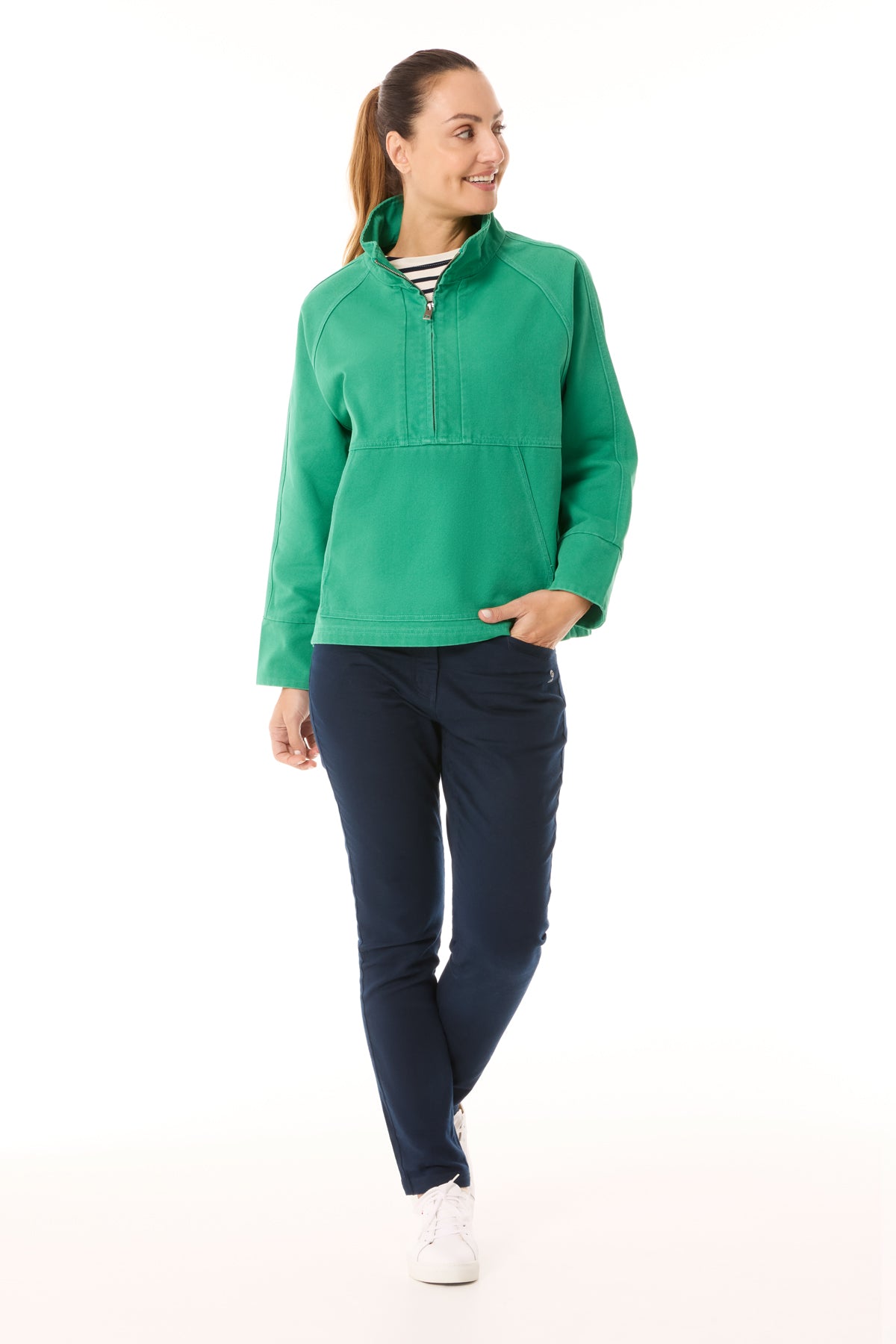 Image of a woman wearing the Mousqueton Yelli smock style top in jade canvas.